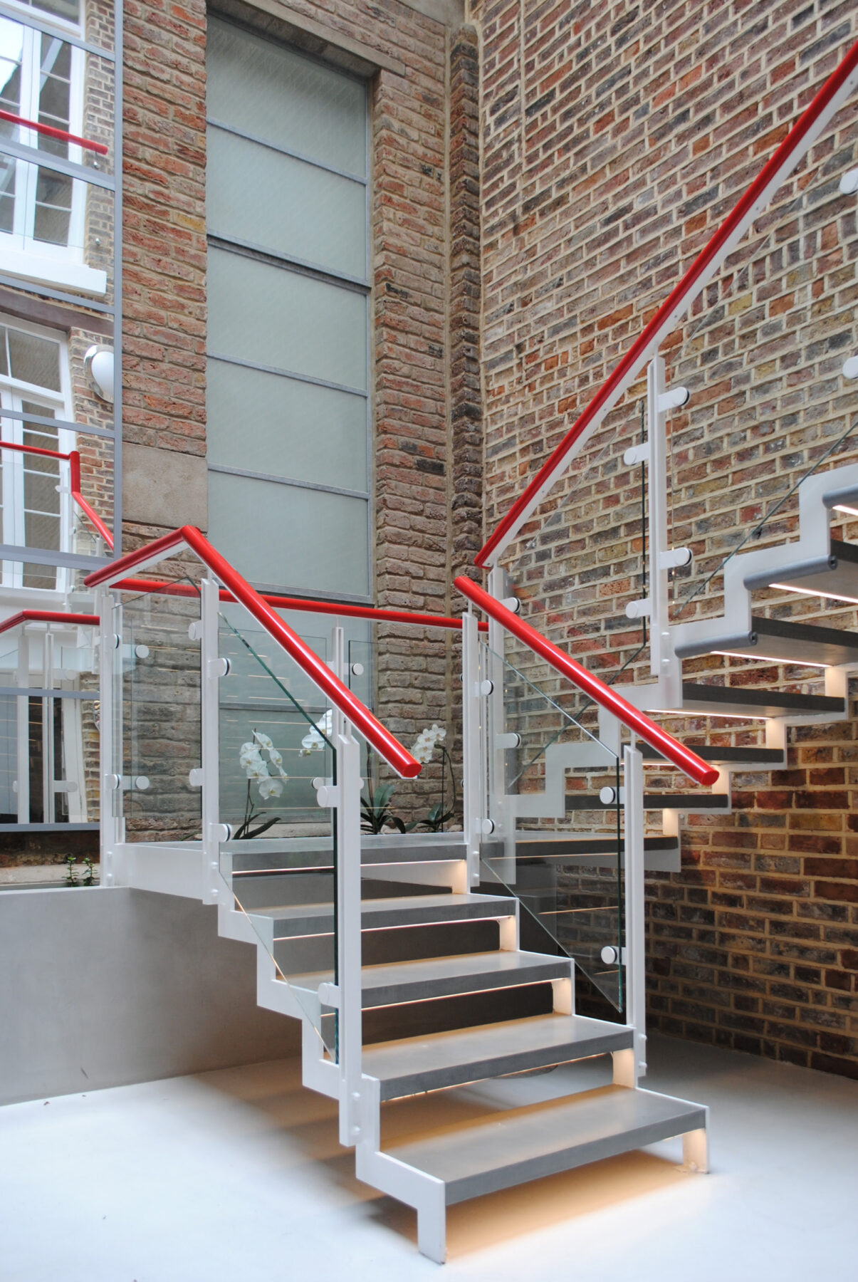 Photo of contemporary open tread steel and glass stair